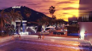 A vibrant sunset illuminates a luxurious pool area surrounded by palm trees, with people enjoying the water and relaxed seating nearby.