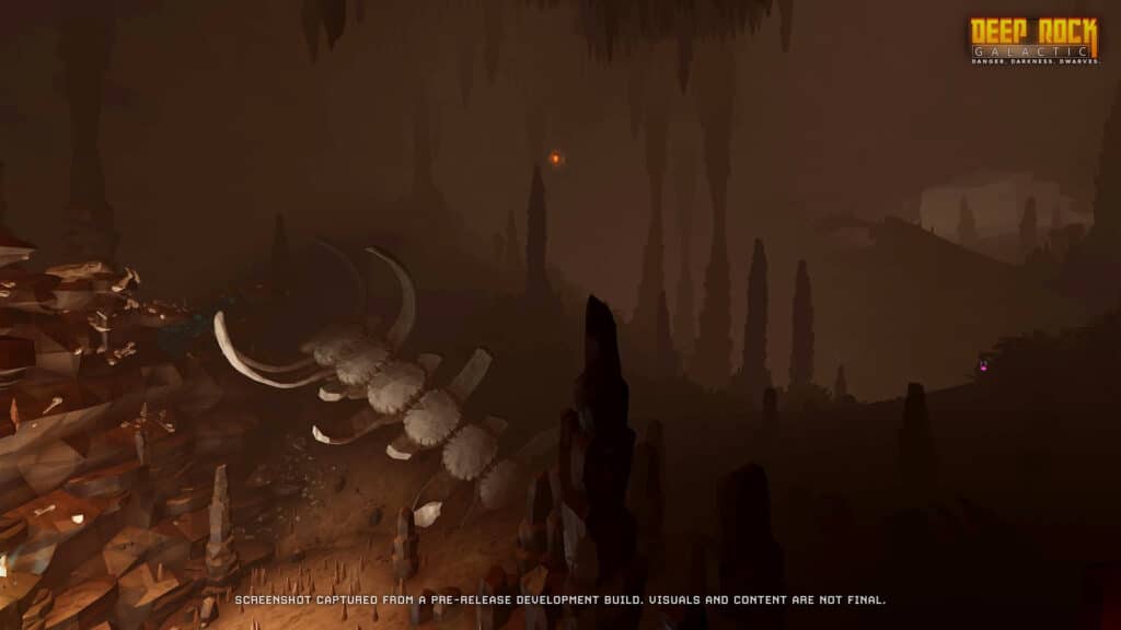 A dark cavern filled with towering pillars and giant skeleton remains in the Deep Rock Galactic game